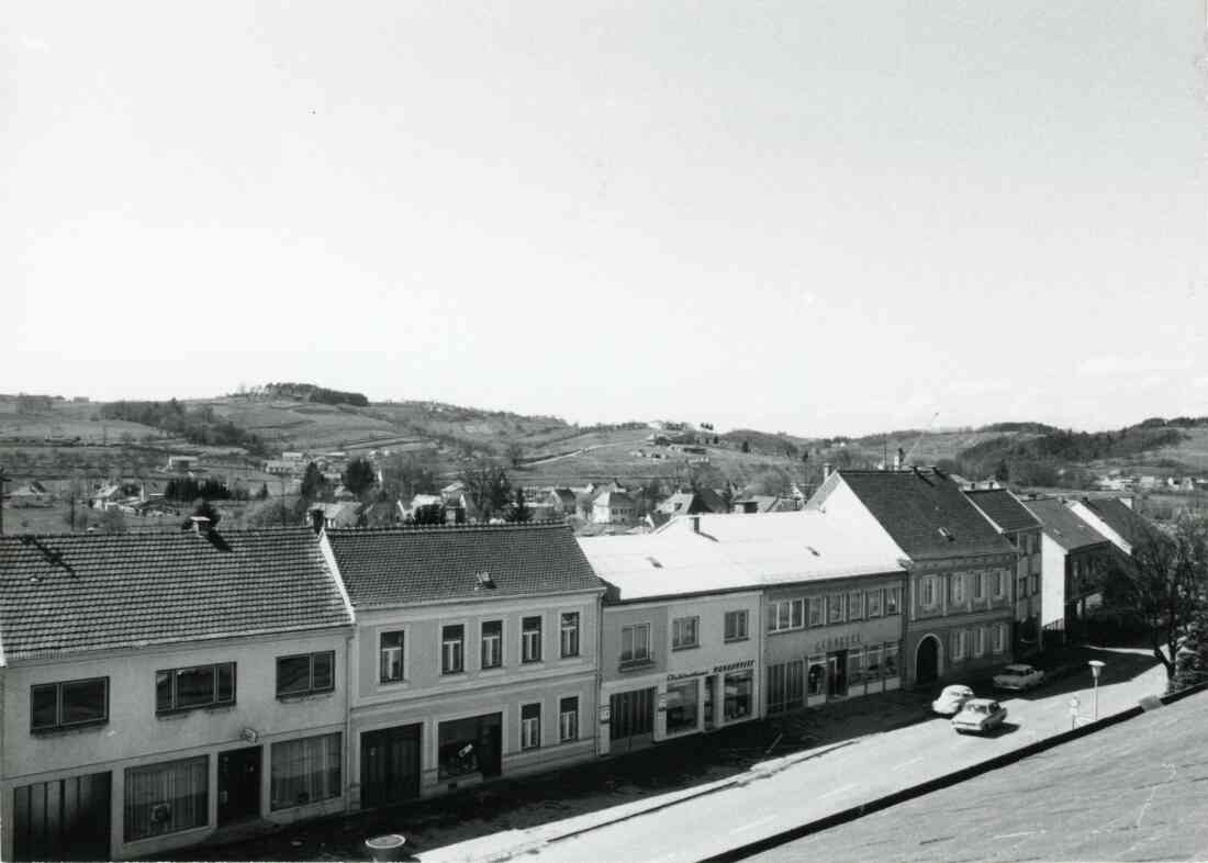 Hauptstraße und mit Friseur Mandler, Elektrohaus Radanovits und Apotheke am 10. April 1973