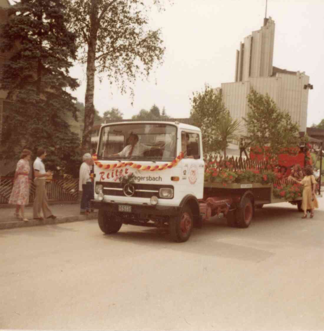 Volksfest mit Blumenkorso in der Kirchengasse mit der Heilig Geist Kirche und den blumengeschmückten LKW des Geschäftes Reiter